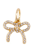 Gold bow-shaped pendant with embedded crystals on a white background